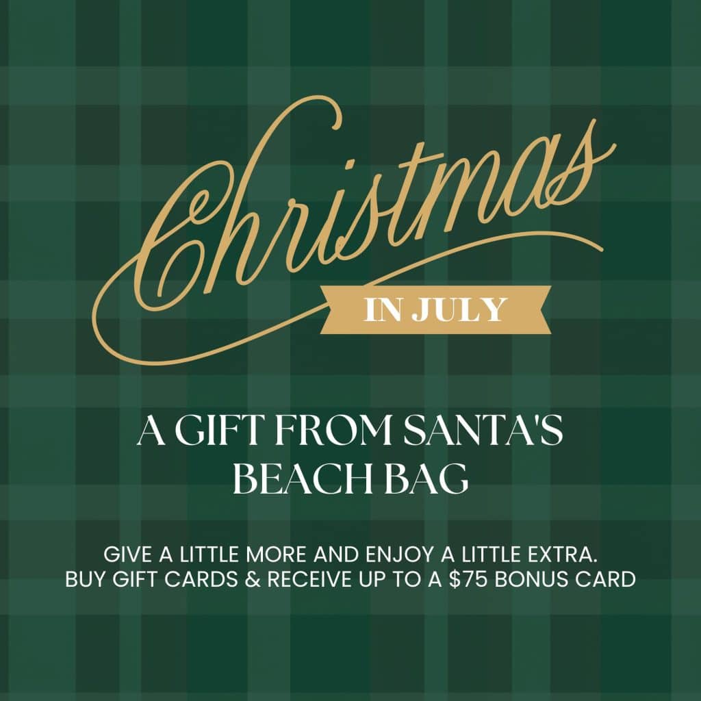 Green plaid promotional banner with gold script reading 'Christmas' and a beige ribbon saying 'IN JULY', advertising gift cards from Santa's Beach Bag.